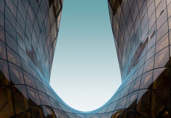 Symmetrical glass structure reflecting blue sky