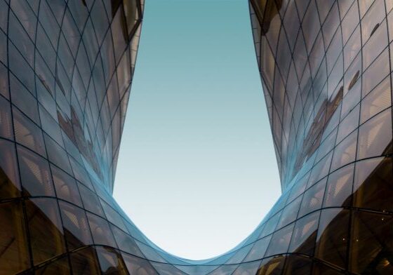 Symmetrical glass structure reflecting blue sky